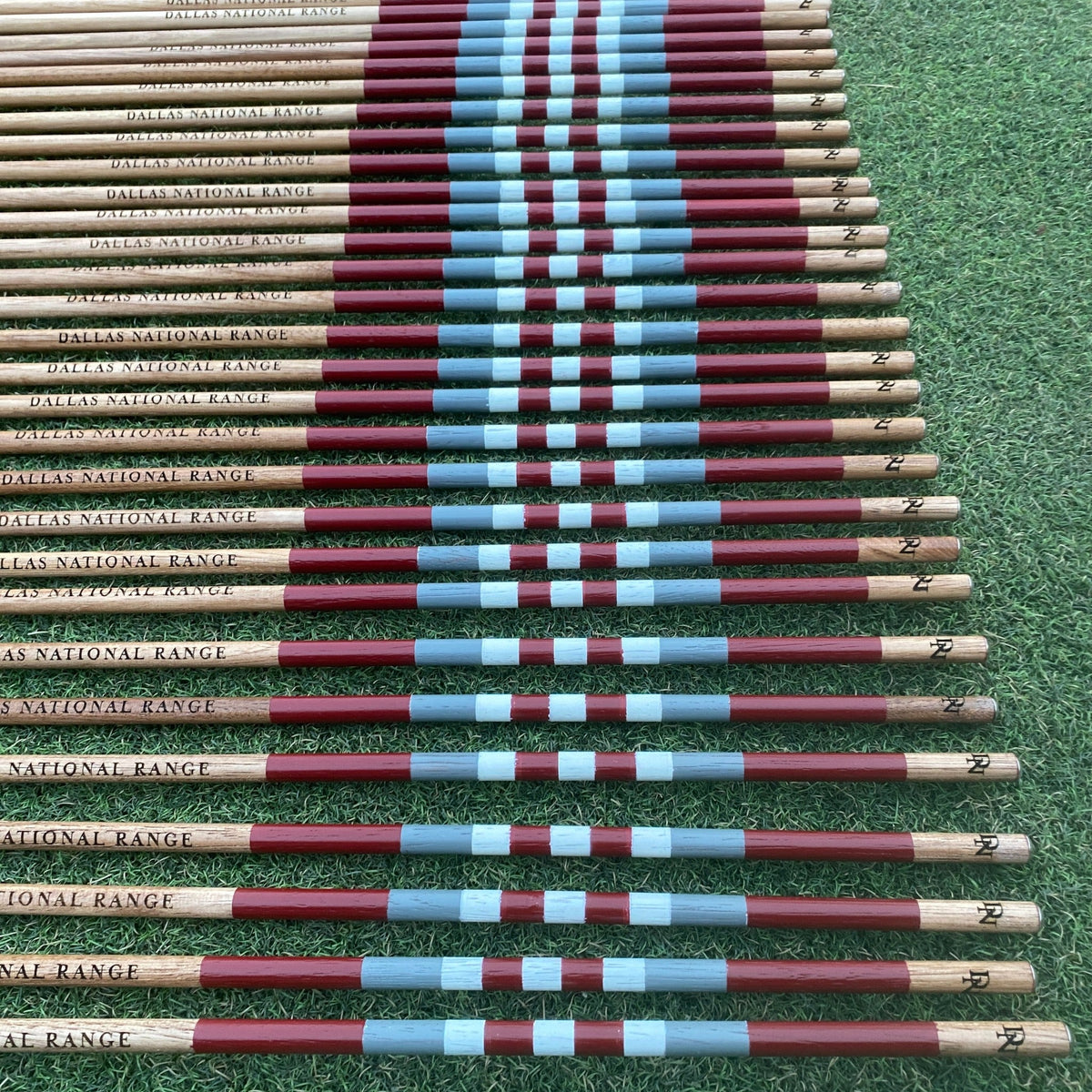 Dallas National Golf Club custom hickory alignment sticks in burgundy and blue on the practice range