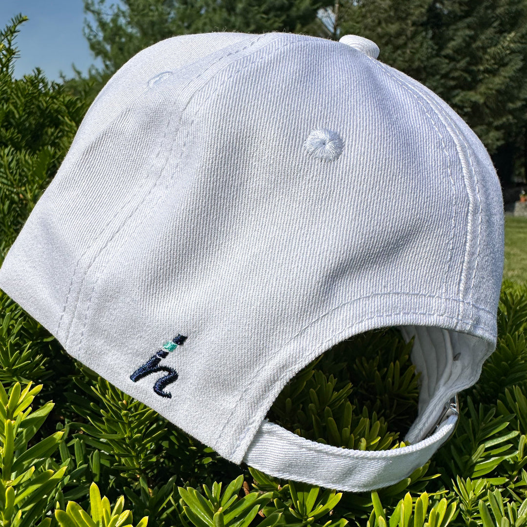 White cap with a logo on grass